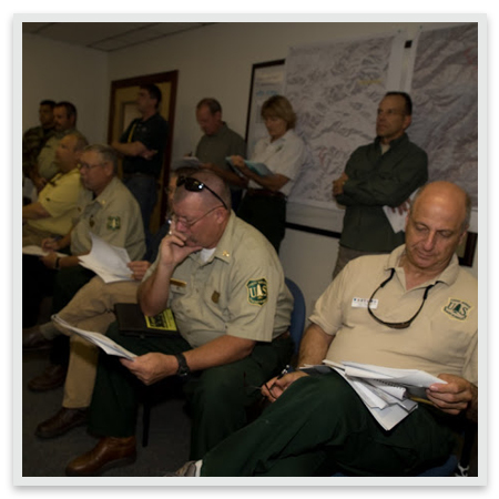 Agency administrators review briefing material during a meeting
